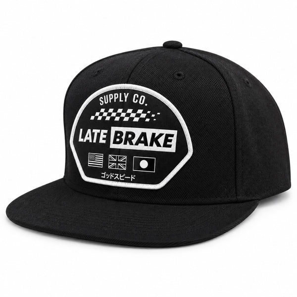 Late Brake black flat brim cap with a white LATE BRAKE patch on a white background.