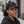 Woman wearing a Late Brake black mesh trucker hat with a tonal LATE BRAKE wordmark outdoors.