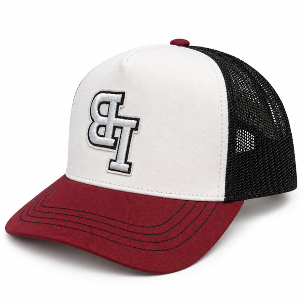 Late Brake burgundy, white and black trucker hat with an embroidered LB monogram on a white background.